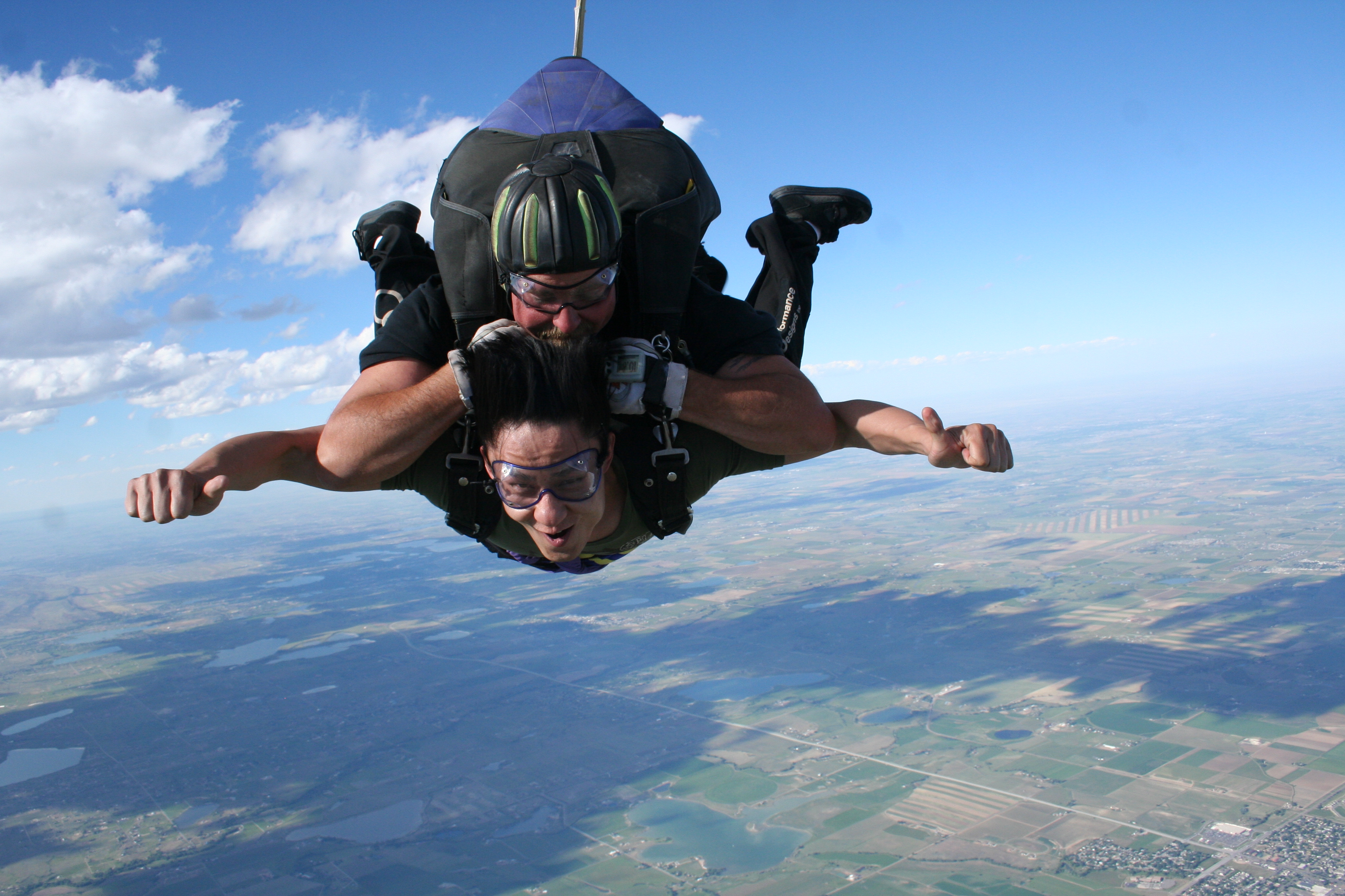 Tandem skydiving above farmland